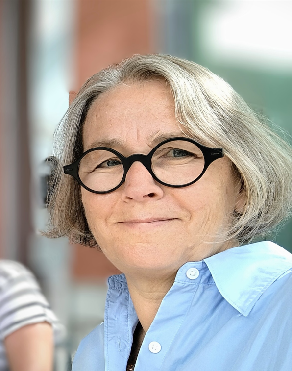 Kvinna med glasögon och blå skjorta. Styrelse.