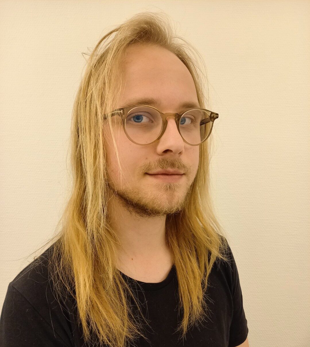 Man med långt blont hår och glasögon. Porträtt.