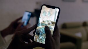 Smartphone visar AR-vy av ett vardagsrum med möbler. "Gently touch the sofa