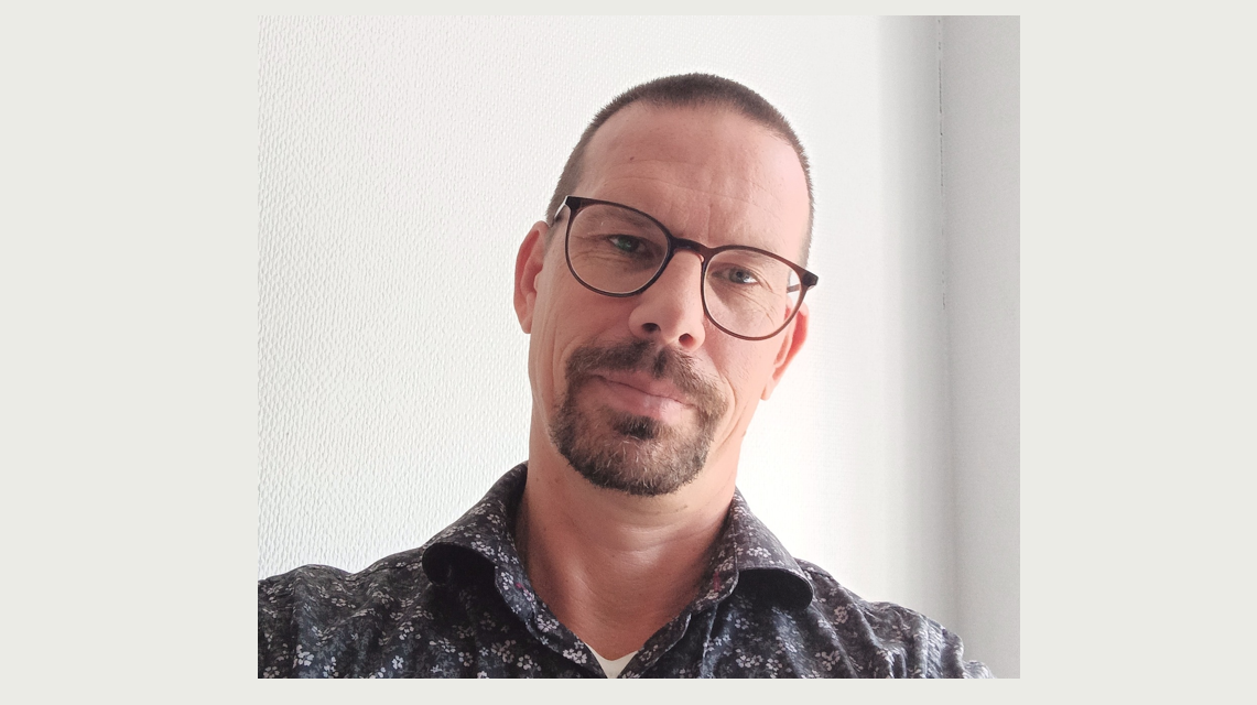 Man med glasögon och skägg. Kontakta oss.