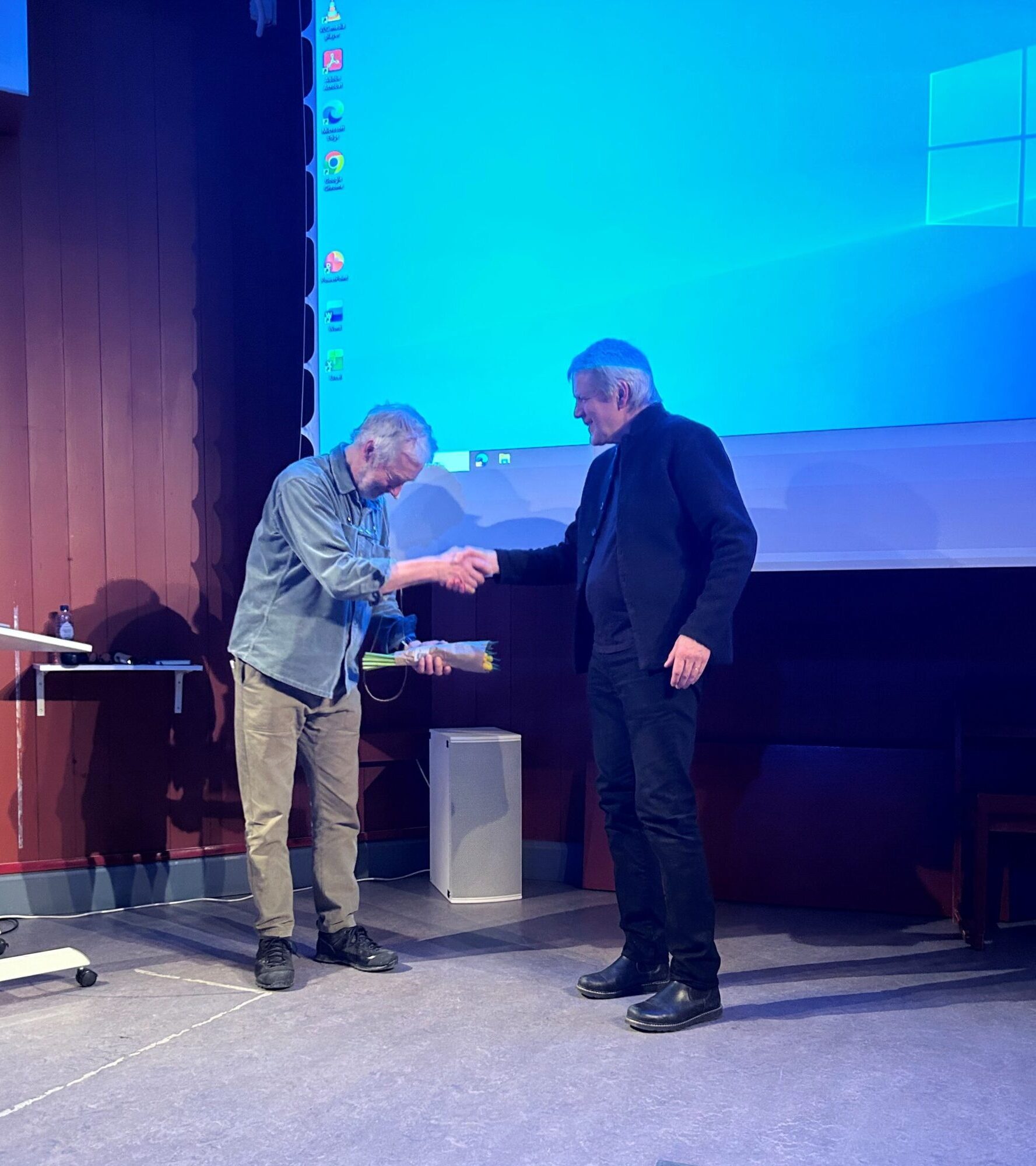 Två män skakar hand vid distriktsstämma Jämtland-Härjedalen 2026.