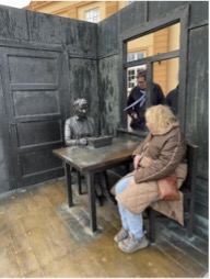 Besökare vid en skulptur som föreställer ett möte, som påminner om årsmöte.